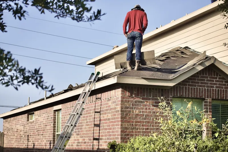Professional roofer working on a residential roof in East Acton
